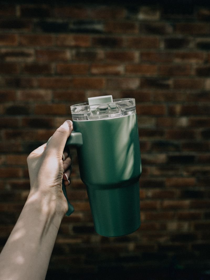 Hand holding an insulated stainless steel tumbler cup