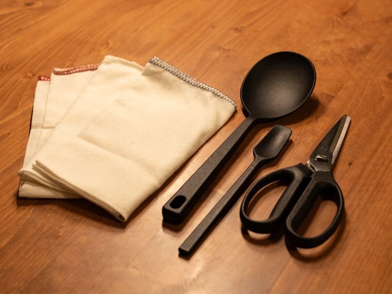 Kitchen utensils set laid out on a wooden table